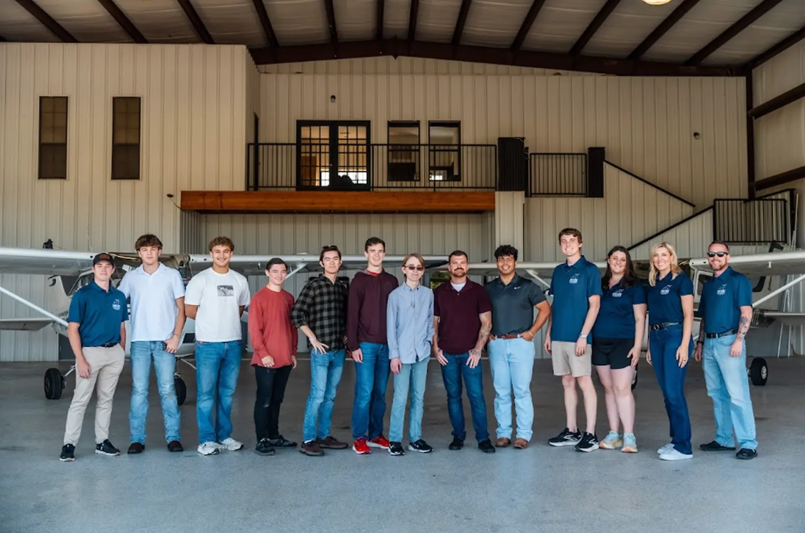 Bird Dog Flight Services Team at hangar with planes behind