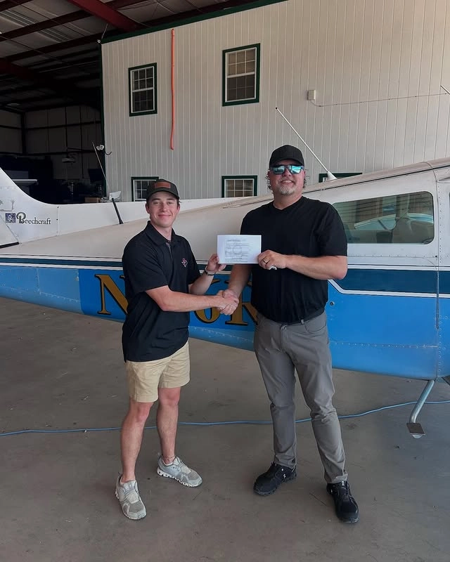 Student pilot holding their certificate after a private pilot checkride in Fort Worth